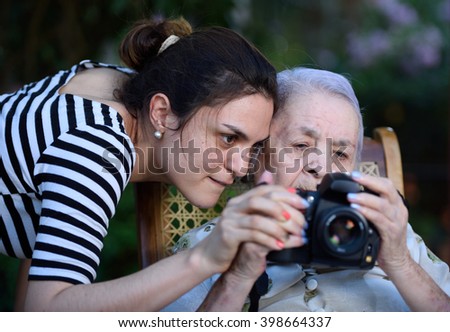grandma browsing photos on DSLR camera with young girl