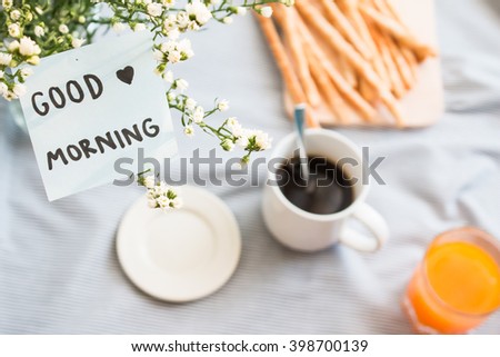 Close up of good morning note on cutter flower and blurry breakfast background.