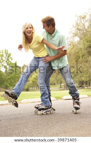 Couple Wearing In Line Skates In Park