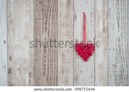 Red wood heart hanging on rustic wooden background