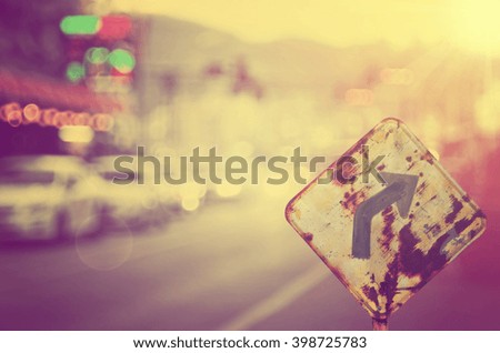 Traffic sign,old curve road sign on blur traffic road abstract background.Retro color style.
