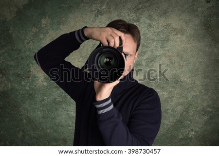 photographer with his camera and green background