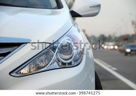 Front look headlamp white car on the roadside Royalty-Free Stock Photo #398741275