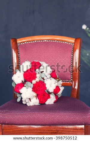 red chair against a textural gray wall and bride bouquet. Grunge style