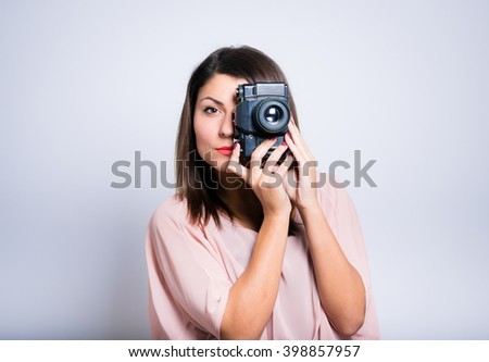 closeup of a young woman taking pictures on vintage camera