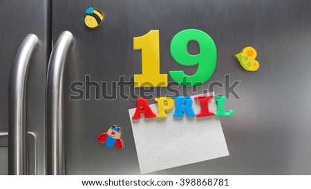 April 19 calendar date made with plastic magnetic letters holding a note of graph paper on door refrigerator                  