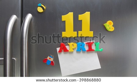 April 11 calendar date made with plastic magnetic letters holding a note of graph paper on door refrigerator