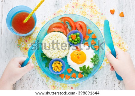 Healthy breakfast for children: fried eggs with vegetables, concept fun baby food top view