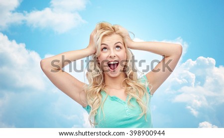 emotions, expressions, hairstyle and people concept - smiling young woman or teenage girl holding to her head or touching hair over blue sky and clouds background