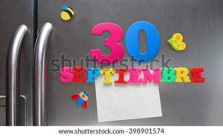 Septiembre 30 (September 30 in Spanish language) calendar date made with plastic magnetic letters holding a note of graph paper on door refrigerator. Spanish version                