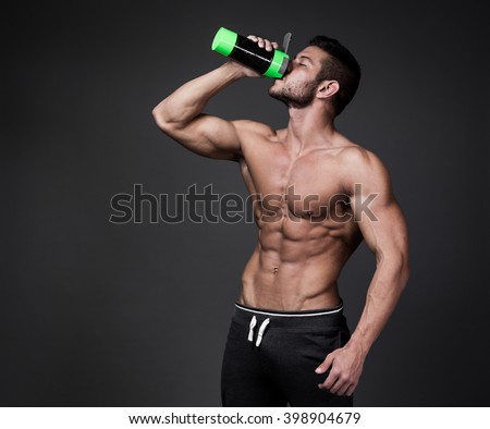Muscular man with protein drink in shaker over black background Royalty-Free Stock Photo #398904679