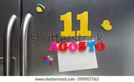 Agosto 11 (August 11 in Spanish language) calendar date made with plastic magnetic letters holding a note of graph paper on door refrigerator. Spanish version                 