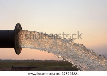 water flow from pipe , sunset  and abstract Royalty-Free Stock Photo #398945221