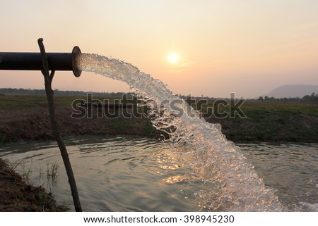 water flow from pipe , sunset  and abstract Royalty-Free Stock Photo #398945230