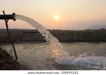 water flow from pipe , sunset  and abstract Royalty-Free Stock Photo #398945242