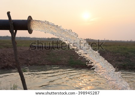 water flow from pipe , sunset  and abstract Royalty-Free Stock Photo #398945287