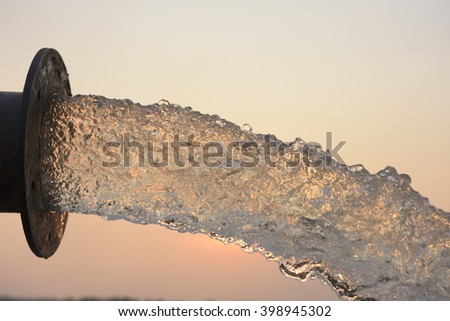 water flow from pipe , sunset  and abstract Royalty-Free Stock Photo #398945302