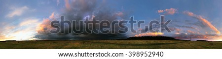 panorama landscape cumulus clouds over the field in the sunset