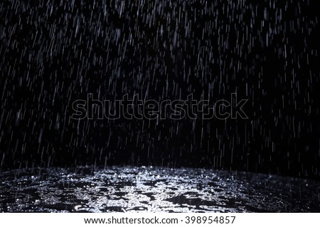Dark background shot of rain falling Royalty-Free Stock Photo #398954857