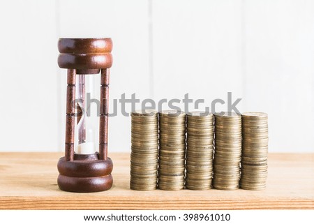 Stack of coins with hourglass , Time to Saving Concept