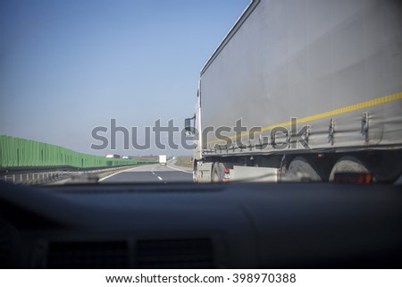 Driving a car in highway with truck