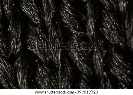 Black nylon mesh cloth fibers under the microscope.