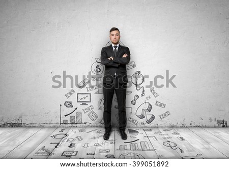 Businessman standing on concrete wall with business sketches passing to the floor. Front view.