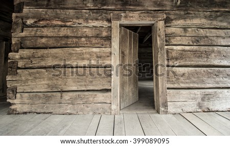 Log Cabin With Open Front Door. Front porch of Appalachian log cabin with open front door.  This is a historical display in the Smoky Mountains National Park and is not a privately owned residence. Royalty-Free Stock Photo #399089095