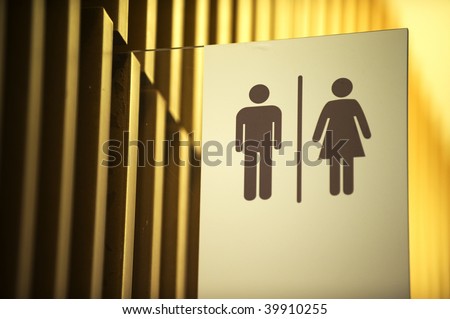Unisex toilet sign against gold background
