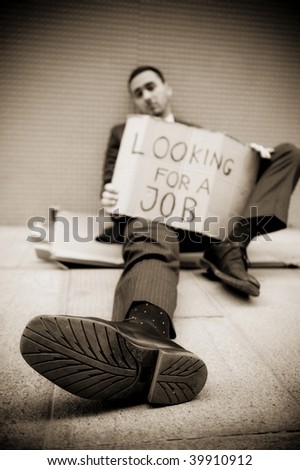 Young businessman holding sign Looking for a job