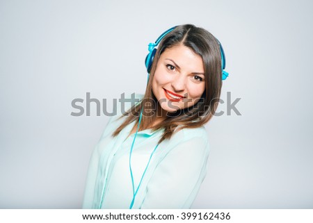 closeup of a young bright woman listening to music on headphones