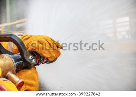 firefighter spraying high pressure water to fire