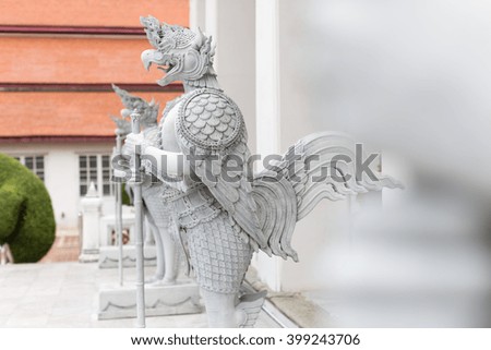 Stucco statue of guardian angel in guarding posture infront of a temple in Bangkok,Thailand