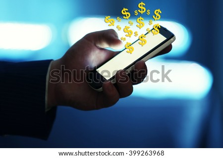 Making money online concept. Male hand touching screen phone with dollar bills coming out close-up