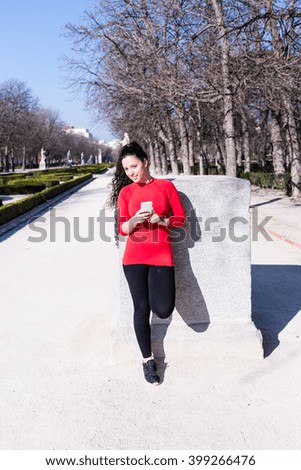 Woman waiting and holding her Phone in a Park