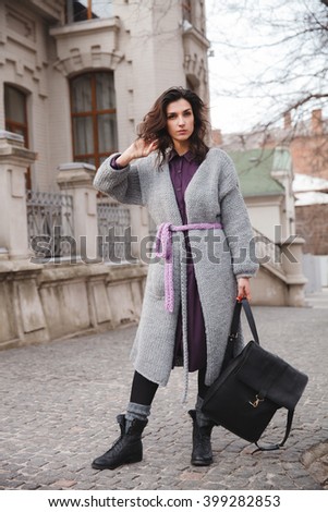 Portrait of young woman wearing colorful knitted clothes. Outdoor, street, lifestyle. Concept of freelance creative working and living.