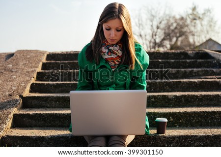 Beautiful woman working on computer in nature
