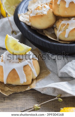 Cinnamon rolls with lemon glaze in wooden plate