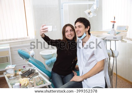Dentist man with his patient doing photo selfie in dental office