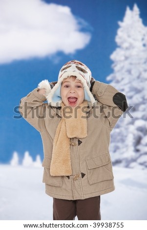 Portrait of happy kid wearing warm clothes in snow on a cold winter day, smiling.