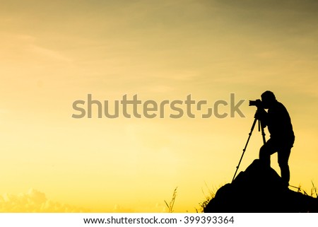 silhouette of photographer who shoots a sunset in the mountain