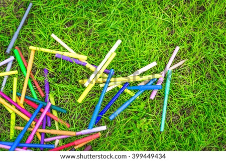 Colourful pen on Green Grass background.