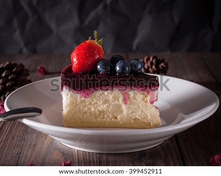 Blueberry cheesecake decorate with pine-corn and dry flower on wood board