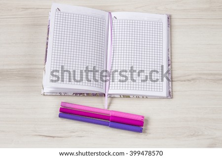 Notebook with colorful marker on wooden table