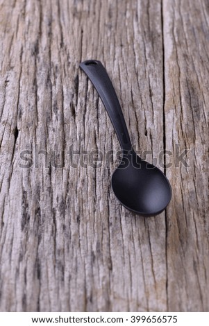 black kitchen ladle or spoon, spatula, fork on a wooden background.