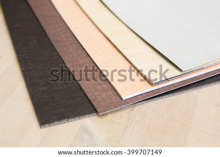 sheets of gray and brown paper for scrapbooking on a wooden table on a light background