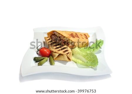 Grilled burrito with beef decorated by tomato, pickled cucumbers and fresh salad. Isolated on white