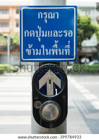 push button for Red traffic light in Thailand. thai language -- (Selective focus)