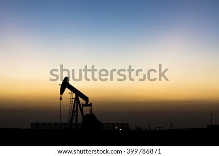 Blue hours after sunset and silhouette of crude oil pump in the oil field
