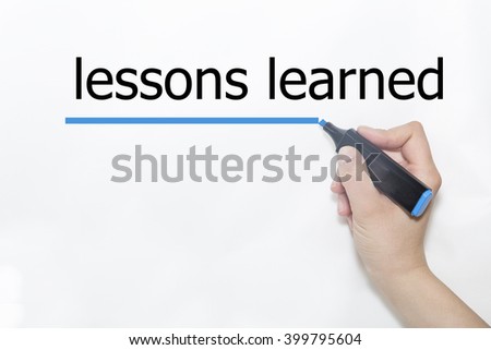 Hand writing lessons learned with blue marker on transparent wipe board. Royalty-Free Stock Photo #399795604